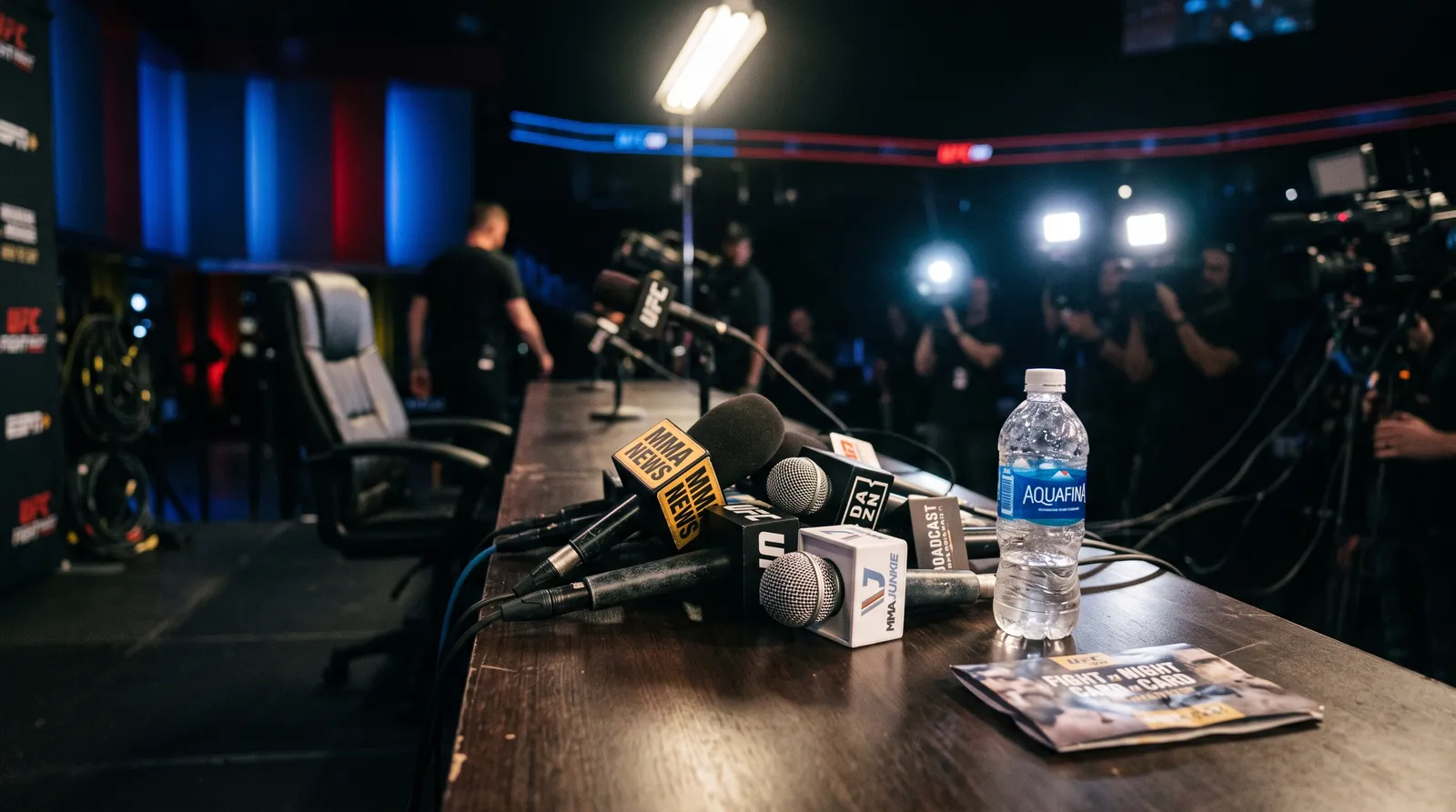 Microphones lined up on a press conference table late at night after a UFC event