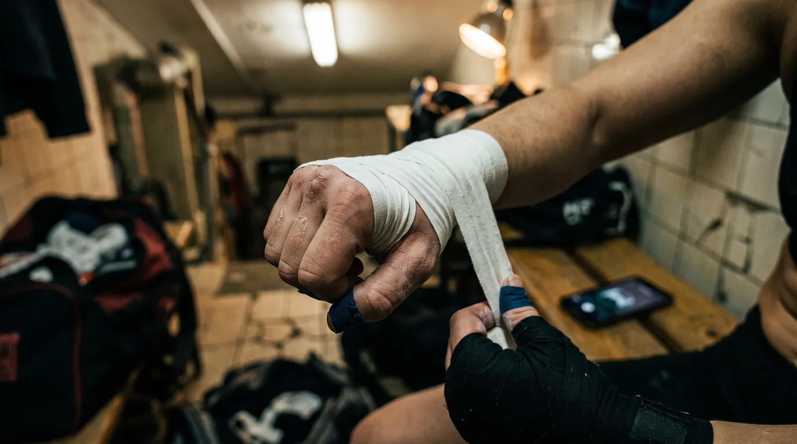 A female fighter's hands being taped in a locker room before a UFC bout